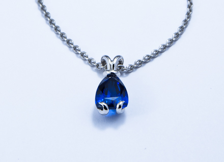 Bunny platinum pendant with a sail shaped blue sapphire