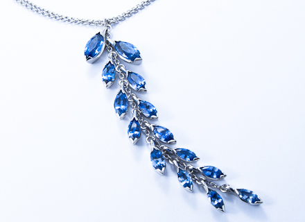 Floral platinum pendant with graduating marquise cut blue sapphires