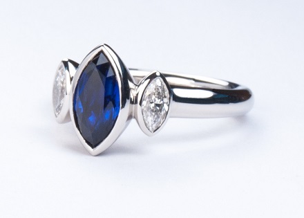 Rub over three stone platinum ring with marquise cut sapphire and diamonds