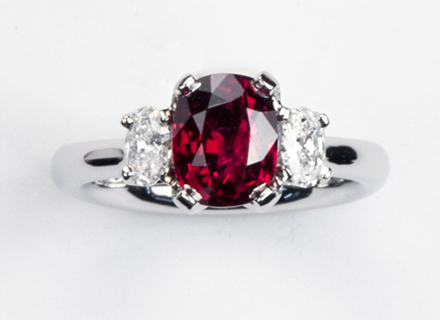Four claw three stone platinum ring with cushion cut ruby and diamonds